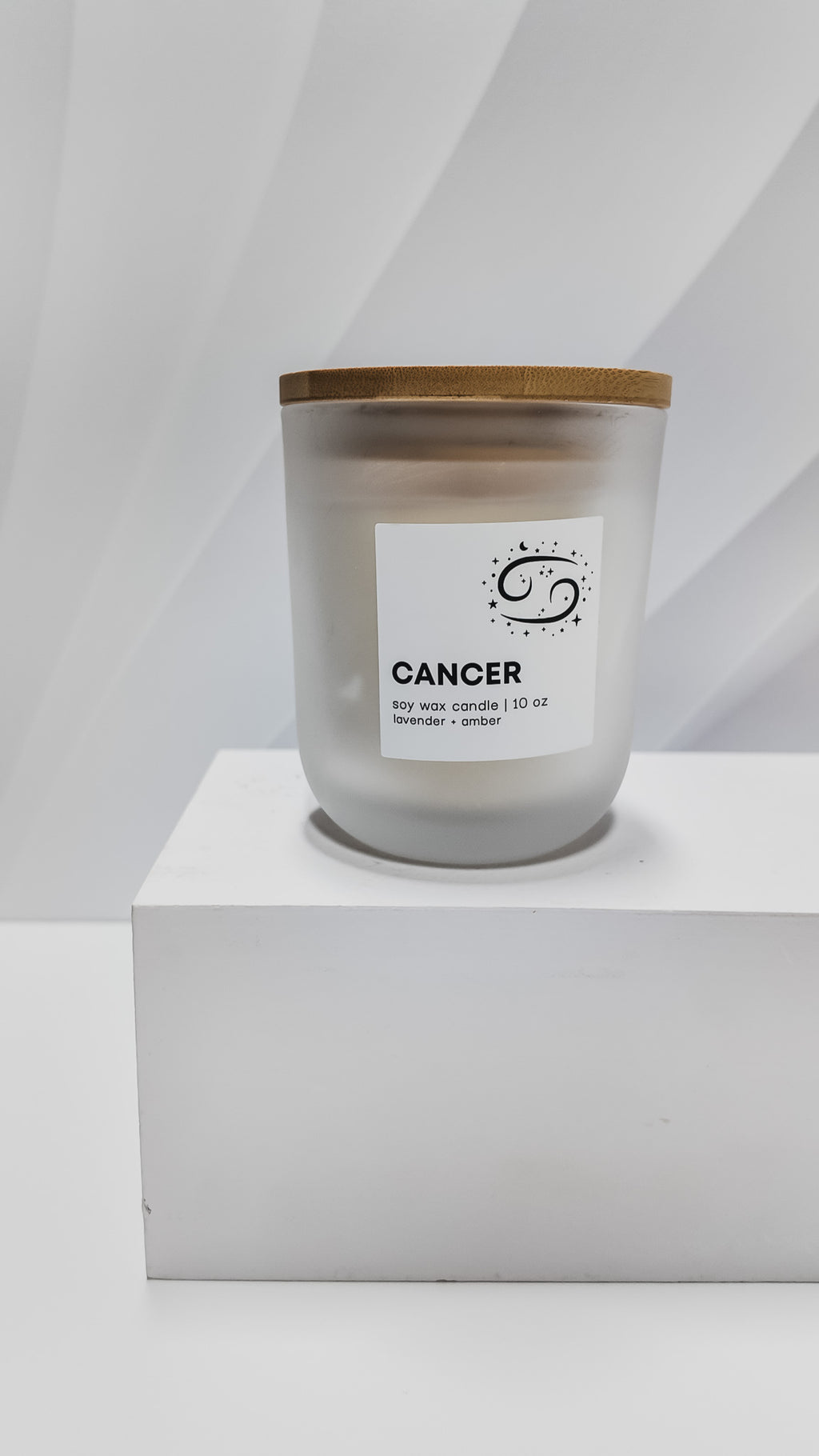 Candle labeled 'Cancer' on a white pedestal with a white background